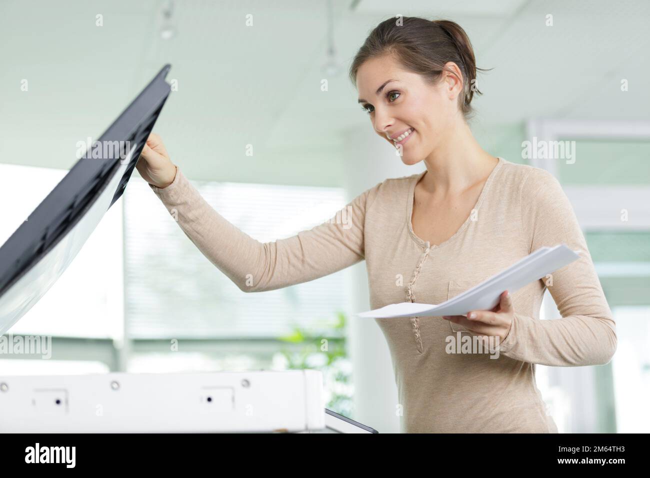 happy teacher printing off work sheets for her next lesson Stock Photo
