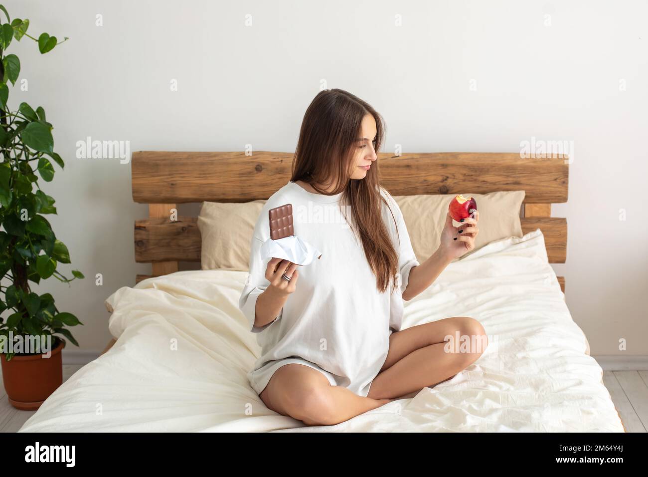 Cute pregnant woman choosing what to eat Stock Photo