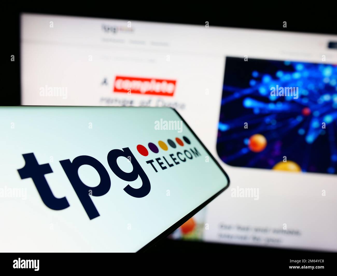 Cellphone with logo of Australian company TPG Telecom Limited on screen in front of business website. Focus on center of phone display. Stock Photo