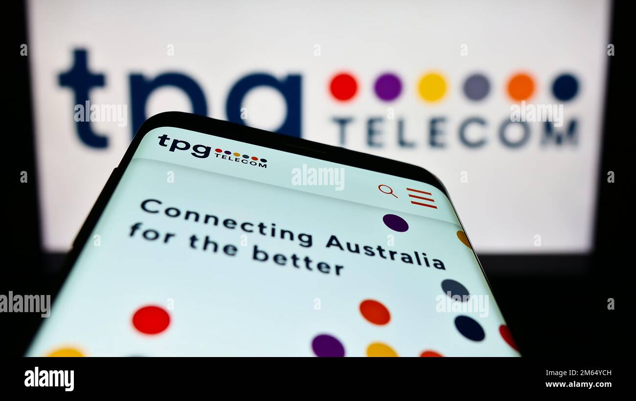 Mobile phone with website of Australian company TPG Telecom Limited on screen in front of business logo. Focus on top-left of phone display. Stock Photo