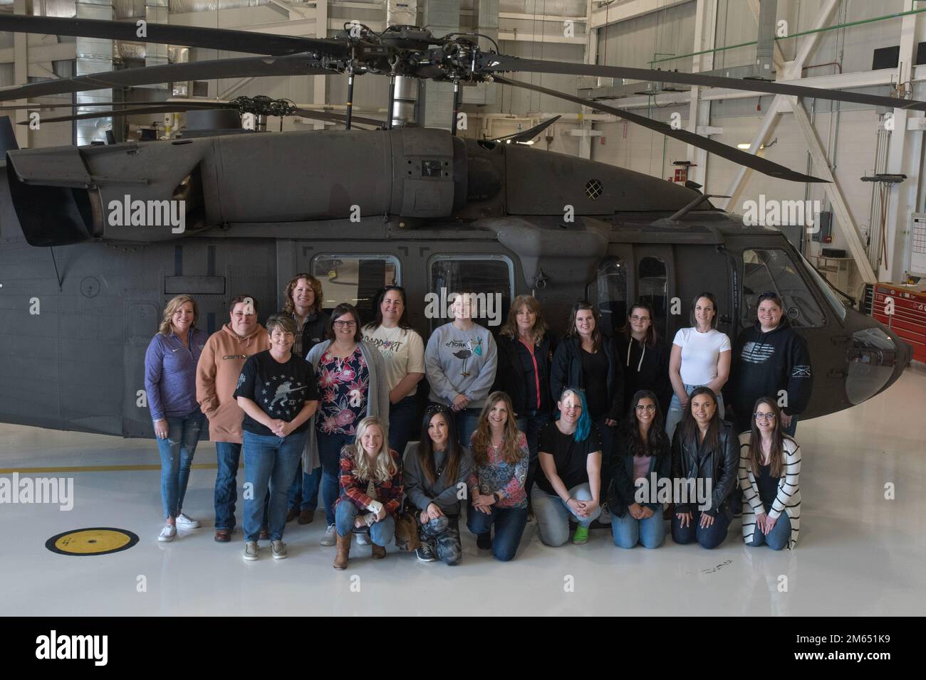 Spouses with the 1-135th Assault Helicopter Battalion pose for a group  photo during the Spouse Orientation Flight Day at Whitman Air Force Base,  Missouri, April 2, 2022. The 1-135th Spouse Orientation Flight