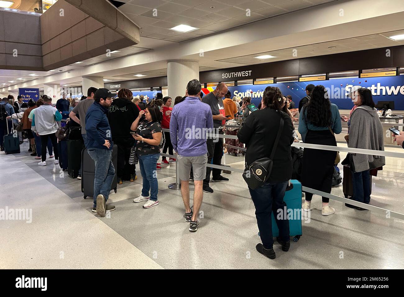 Passengers wait to check in luggage at a Southwest Airlines ticket