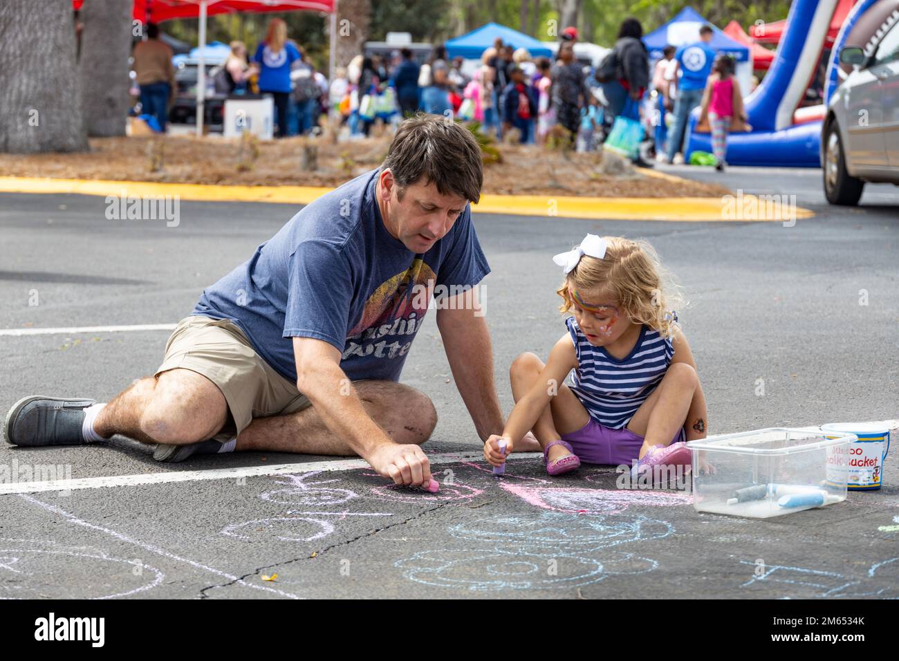 A father and daughter play with chalk at the 24th Annual KidsFest at ...