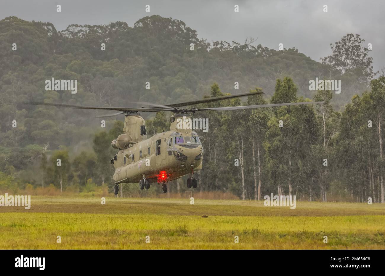 Hawaii Army National Guard Soldiers with Bravo Company, 2nd Battalion, 211th Aviation Regiment, 103rd Troop Command prepare to land the CH-47 Chinook during sling load operations alongside 1st Battalion, 487th Field Artillery Regiment, 29th Infantry Brigade Combat Team at Schofield Barracks, Hawaii, April 02, 2022. Soldiers routinely trained on sling load tactics, techniques and procedures to simulate tactical insertion, extraction and 360-degree security operations of M119 105mm howitzers utilizing air assets. Stock Photo