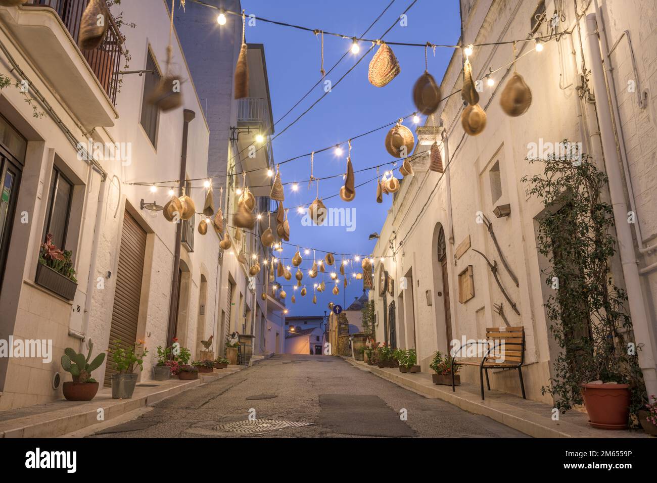 Alberobello, Italy with hanging hatwear in an alleyway at twilight. Stock Photo