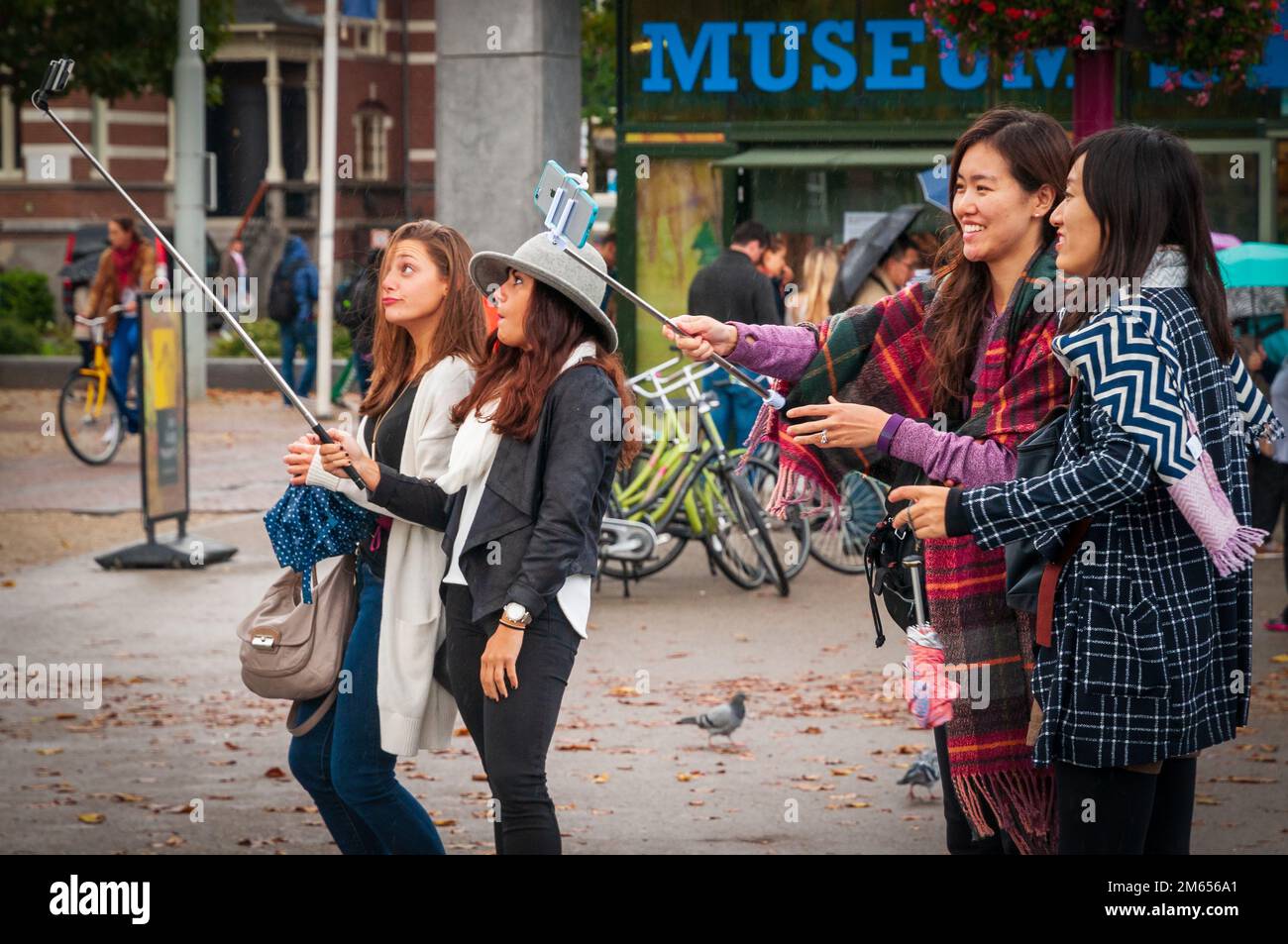 Tourists taking selfies on selfie sticks. Stock Photo