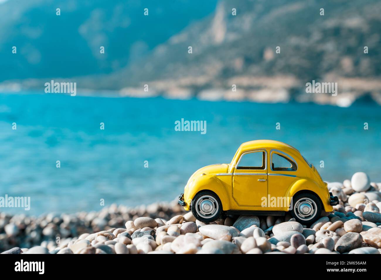 Travel car concept. Toy yellow car moves on against the backdrop of nature. Driving, adventure, discovery idea. High quality photo Stock Photo
