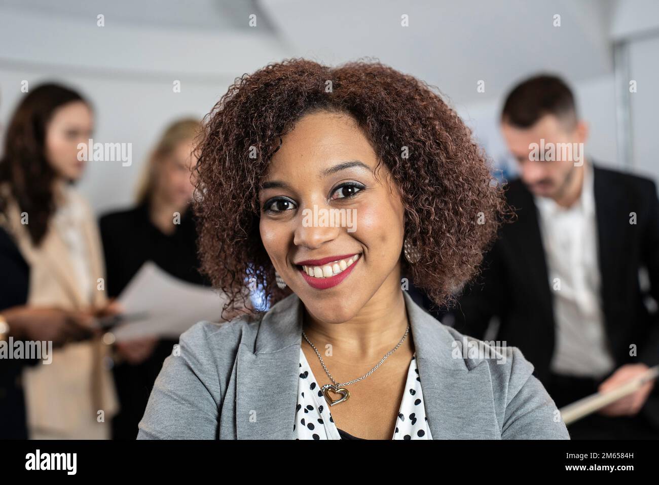 Smiling south american business woman working inside modern office with