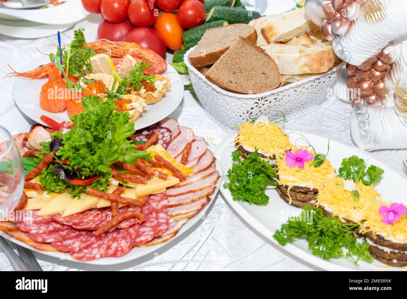 Delicious cold snacks are ready to eat. A variety of cold snacks on the festive table. Cut meat and seafood on the festive table. Stock Photo