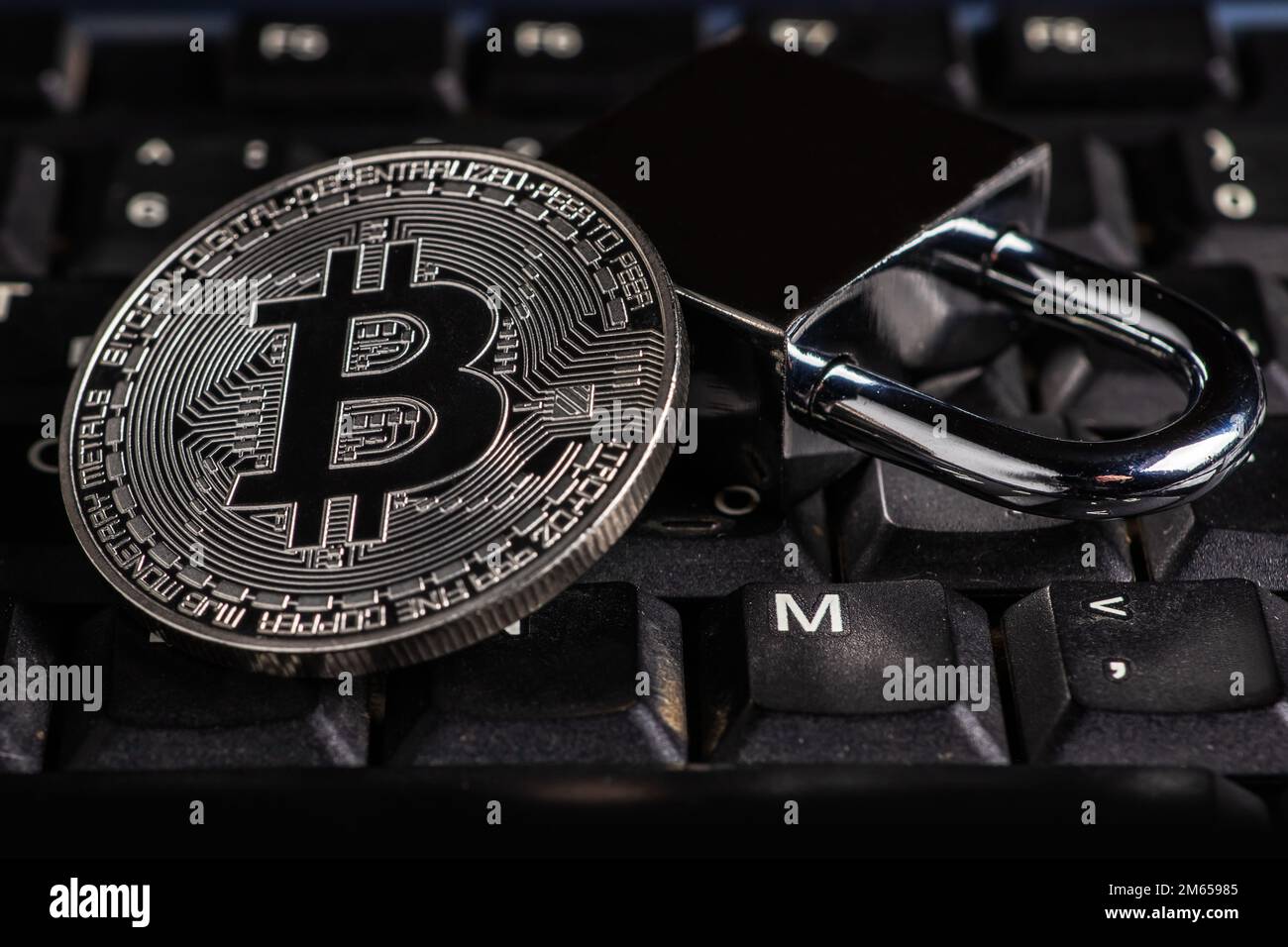 Cryptocurrency bitcoin with lock on keyboard. Bitcoin security. Stock Photo