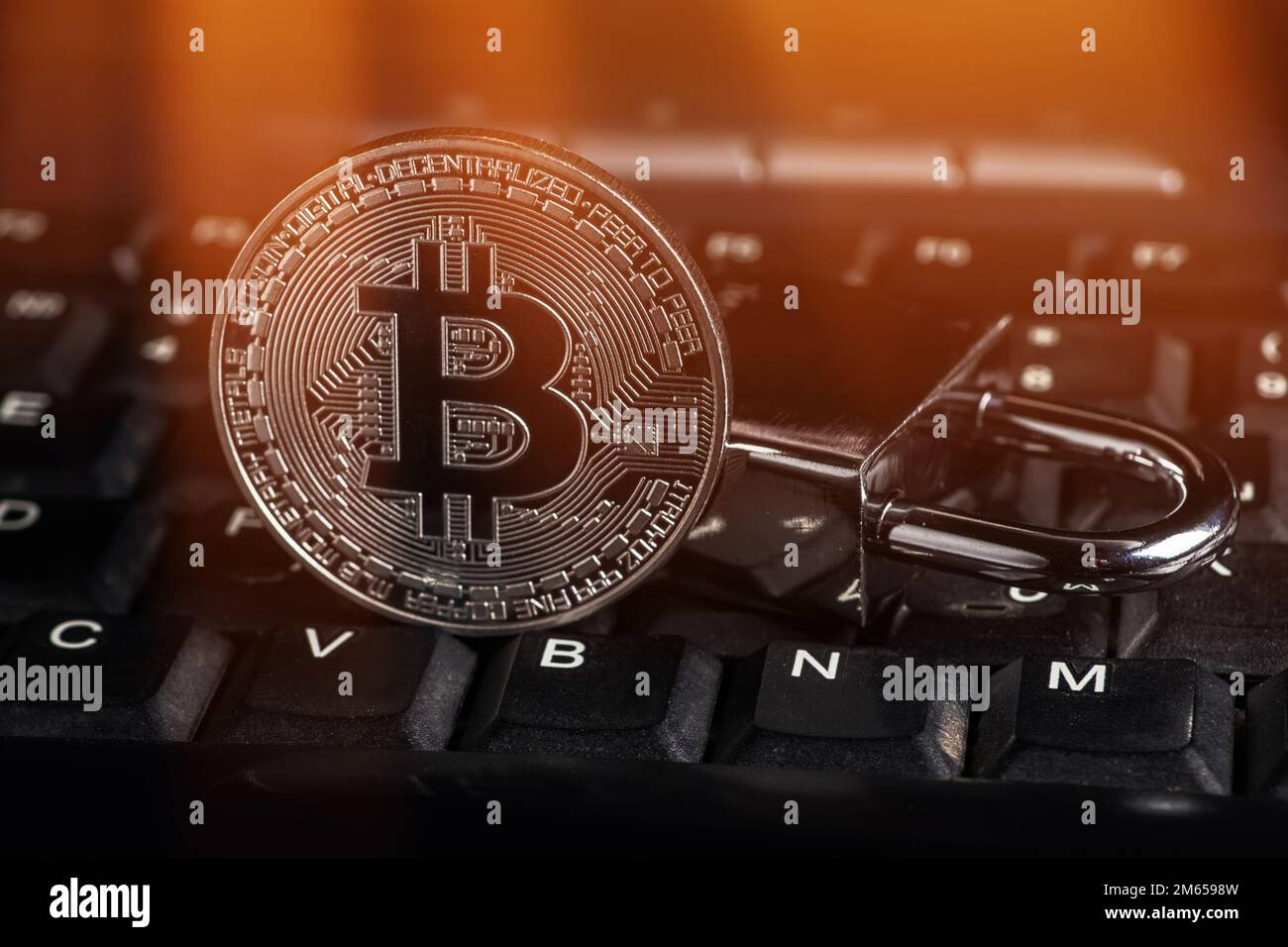 Cryptocurrency bitcoin with lock on keyboard. Bitcoin security. Stock Photo