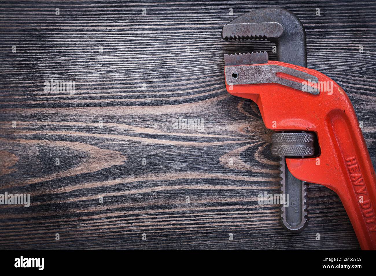 Adjustable pipe wrench on wooden board copy space plumbing concept. Stock Photo