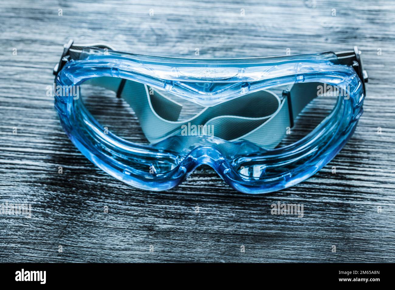 Safety goggles on vintage wooden board. Stock Photo