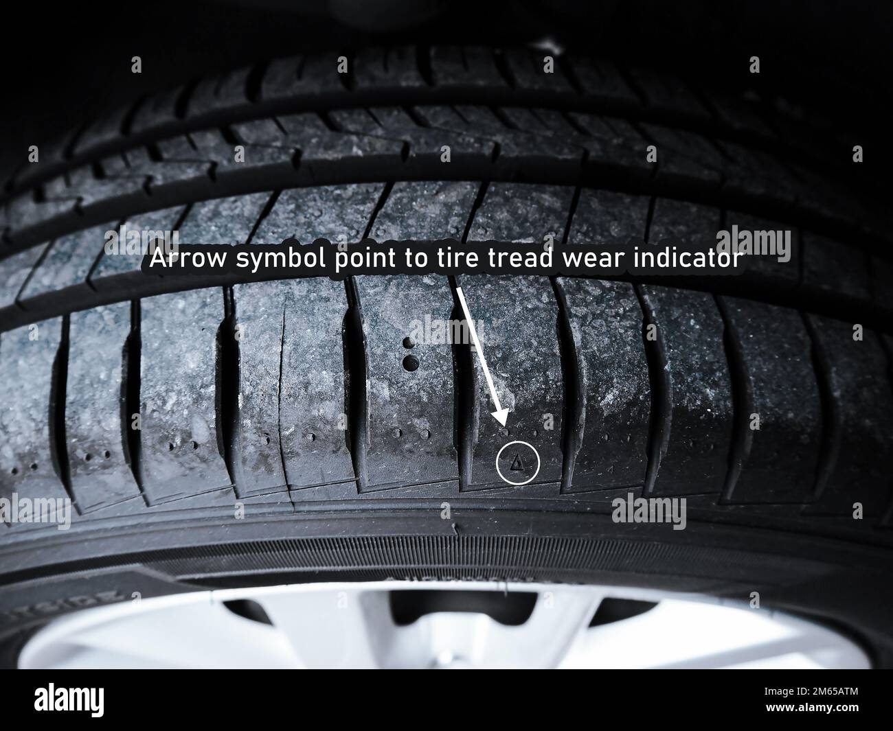 The arrow symbol point to tire tread wear indicator of car tire Stock Photo
