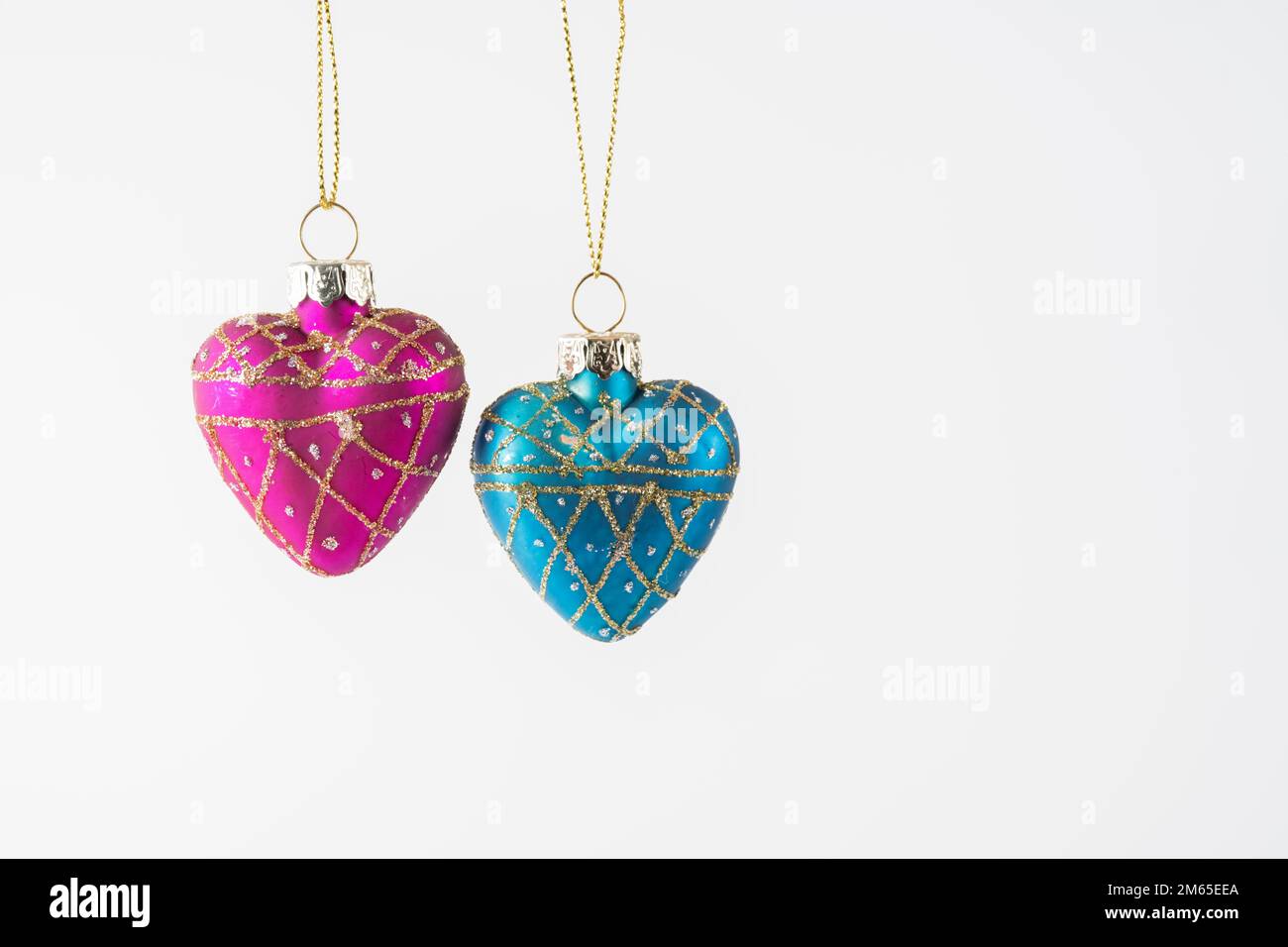 Companionship  love heart pendants suspended and isolated over a white background Stock Photo