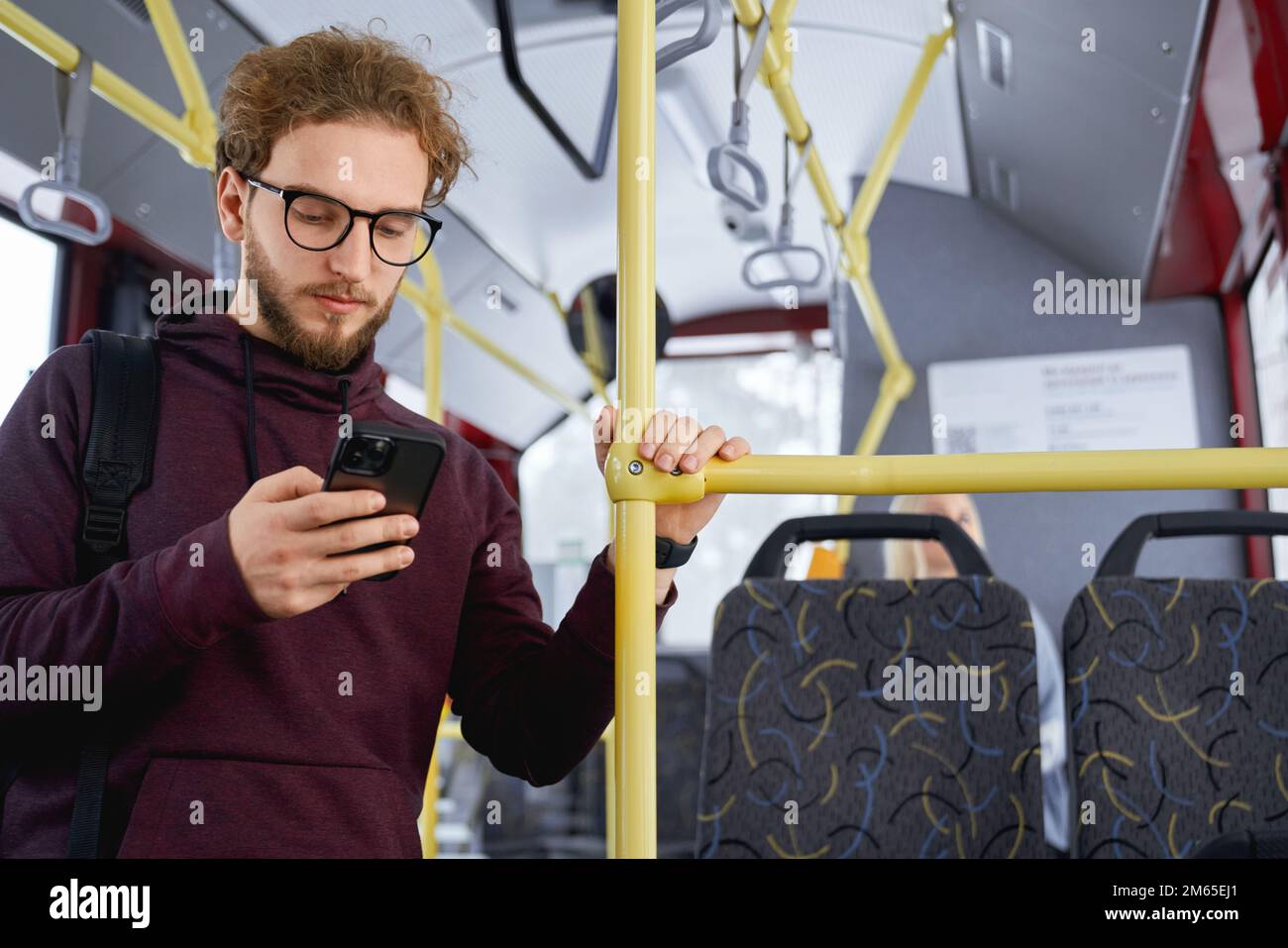Portrait of serious man standing in bus and staring at smartphone concentrated on some issues. Hurry and rush everywhere at work home and public trans Stock Photo
