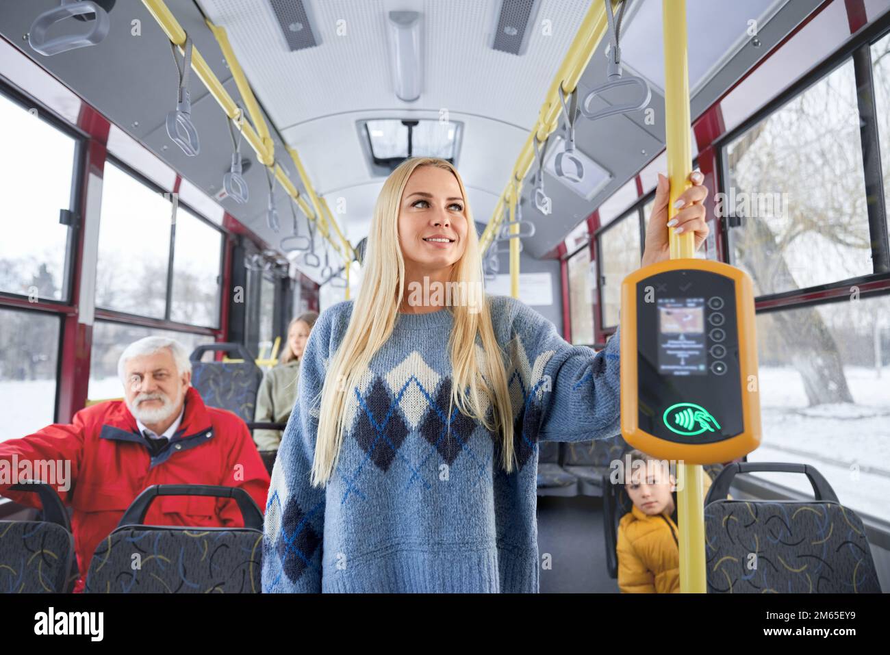 Portrait of young pretty blond woman in blue pullover old gray haired man wearing a red jacket and small boy wearing yellow jacket hurrying to work an Stock Photo
