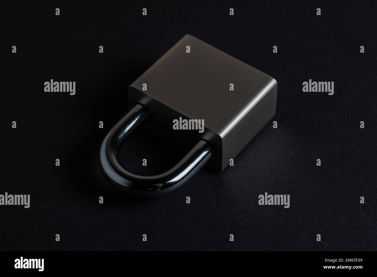 Steel padlock on the black textured background Stock Photo - Alamy