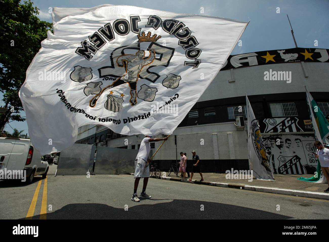 Santos, Brazil. 02nd Jan, 2022. A man waves the flag of Torcida Jovem do Santos, the team that introduced Pelé. Santos fans can say goodbye to Brazilian soccer legend Pele on Monday (02/01/2023). The exceptional footballer Pele died on 29.12.2022 at the age of 82 in Sao Paulo. Credit: Lincon Zarbietti/dpa/Alamy Live News Stock Photo