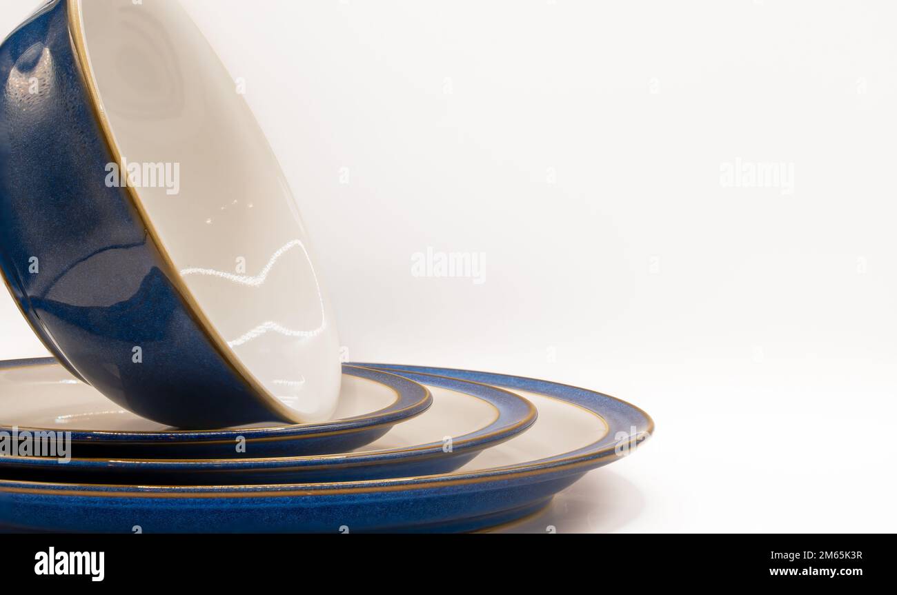 a bowl stood upright and three sizes of crockery plates in white with