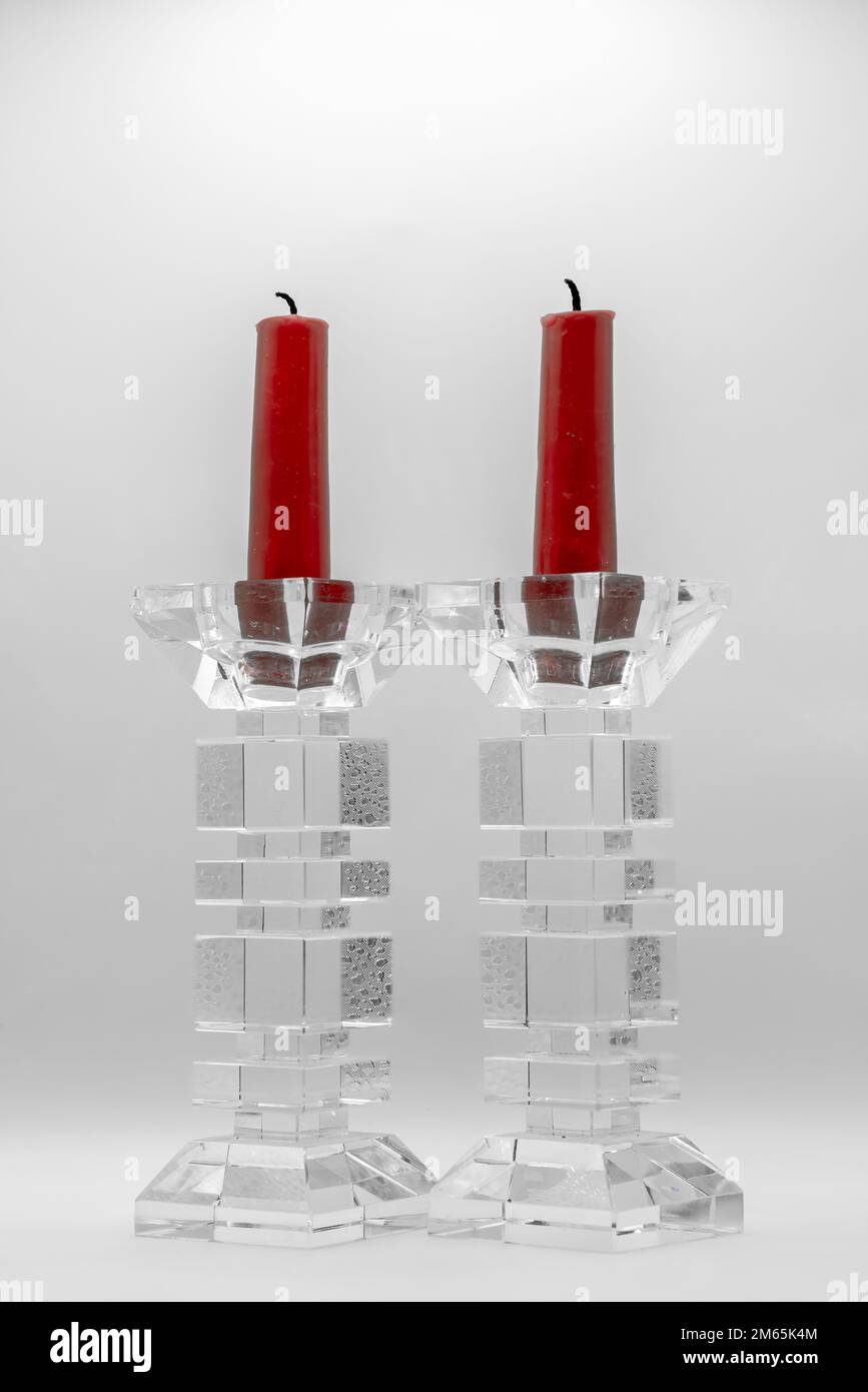 two red candles in clear glass sculptured candle holders Stock Photo