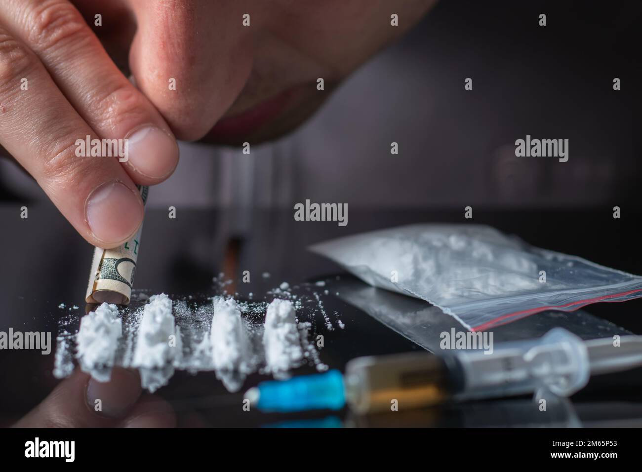 Concept drug addiction.. Drug abuse, man taking drugs, snorting lines of cocaine powder, close up. Stock Photo
