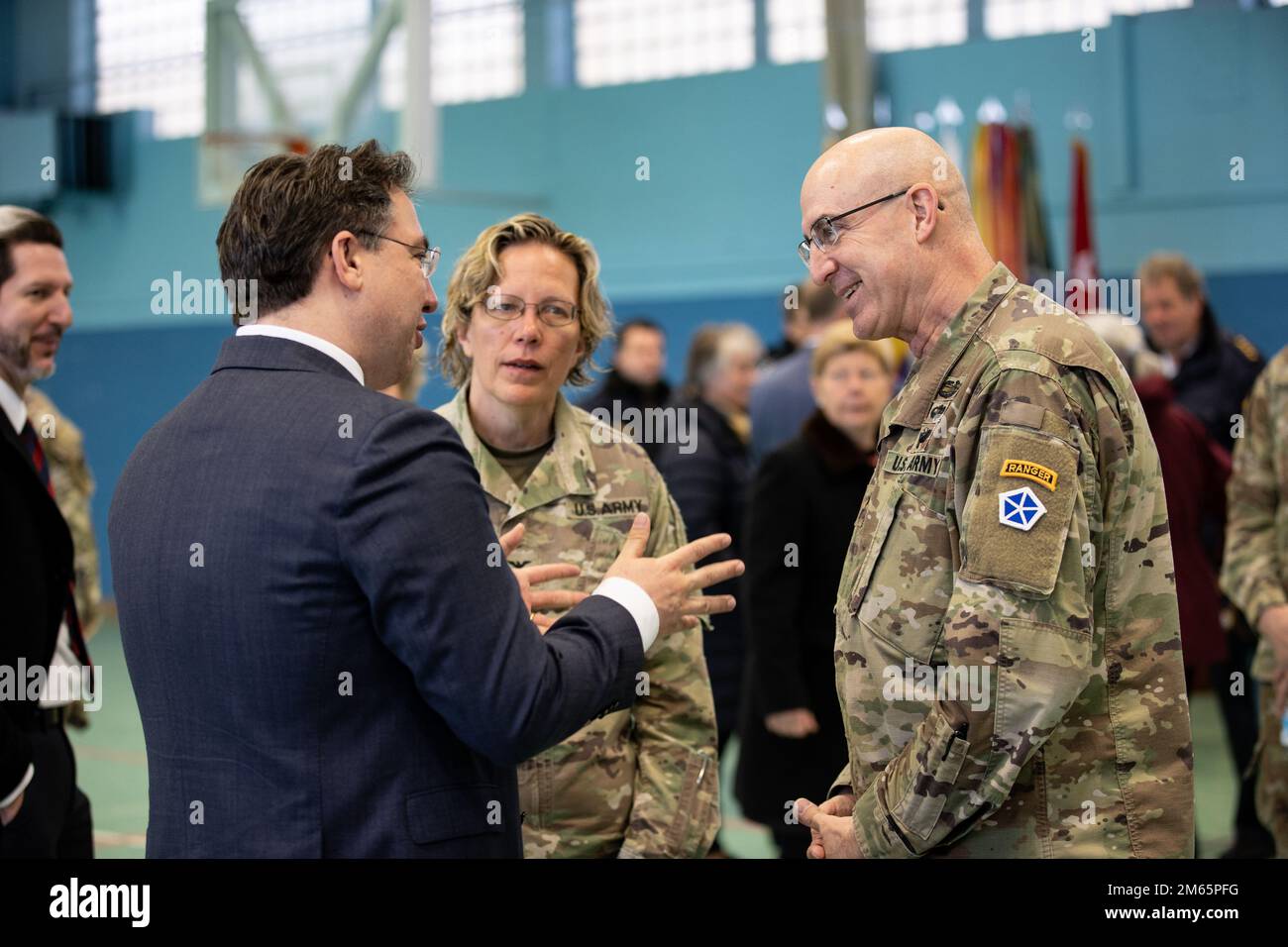 ANSBACH, Germany - Dr. Johannes Urban, ministerial counsellor, Head of Armed Forces Affairs, Security Defense Policy in the Bavarian State Chancellery, left, talks to Maj. Gen. Robert Burke, deputy commanding general of support, V Corps, right, and Col. Karen E. Hobart, commander, U.S. Army Garrison during the U.S. Army V Corps welcome ceremony at Barton Barracks in Ansbach, Germany, Tuesday, April 5. During the ceremony, the V Corps headquarters and the headquarters and headquarters battalion uncased their colors at their temporary home. The presence of the entire Victory Corps headquarters i Stock Photo