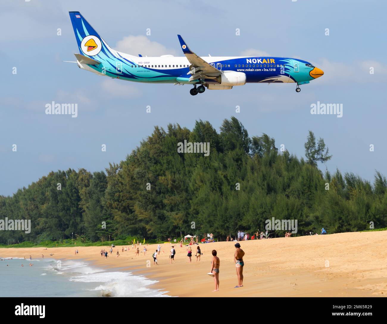 Nok Air Boeing 737-800 airplane flying over Mai Khao Beach near Phuket Airport. Aircraft 737 of NokAir Thailand (Nok Air Thailand). Stock Photo