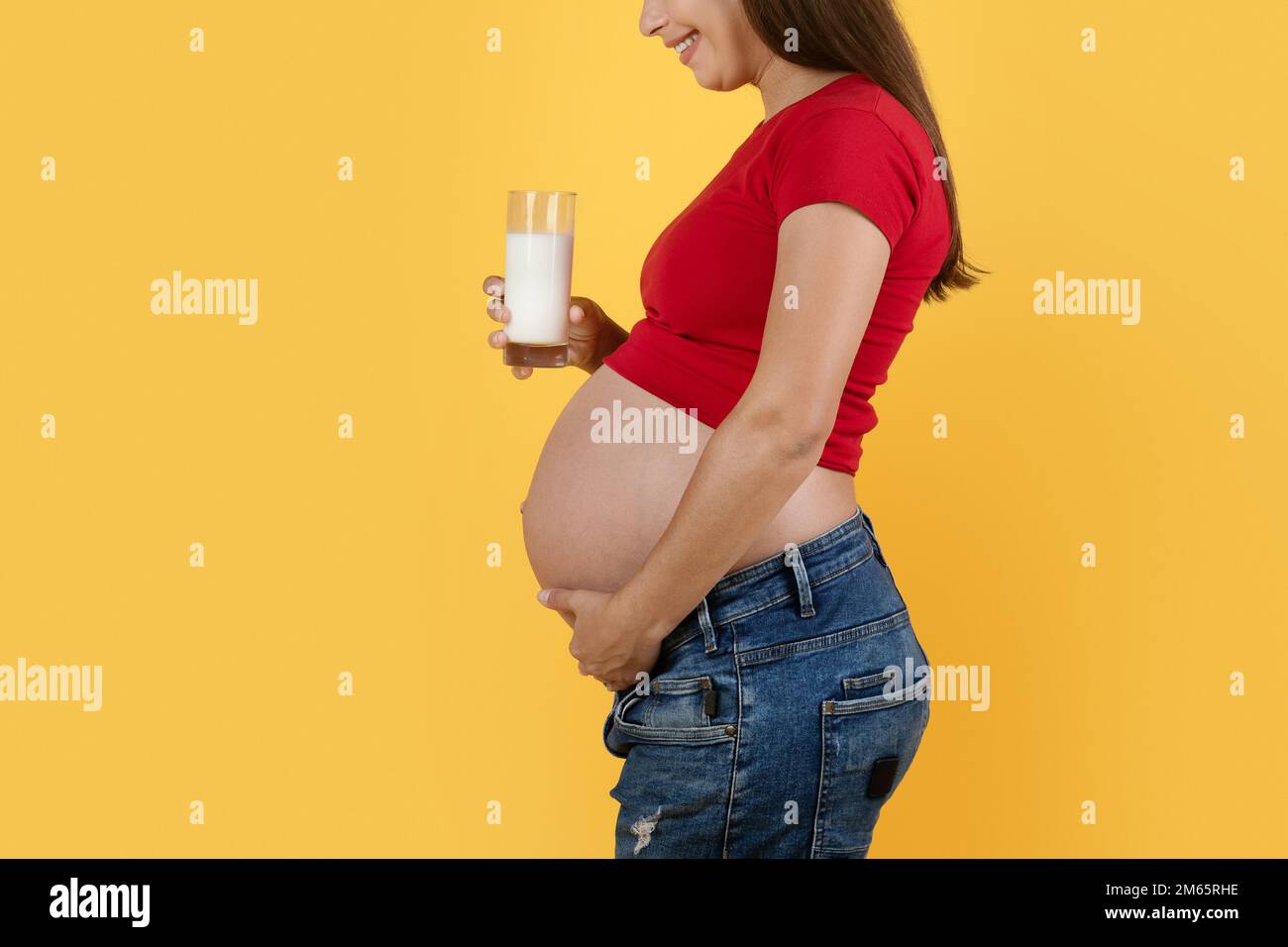 Pregnancy And Dairy Foods. Pregnant Female Holding Glass Of Milk, Side