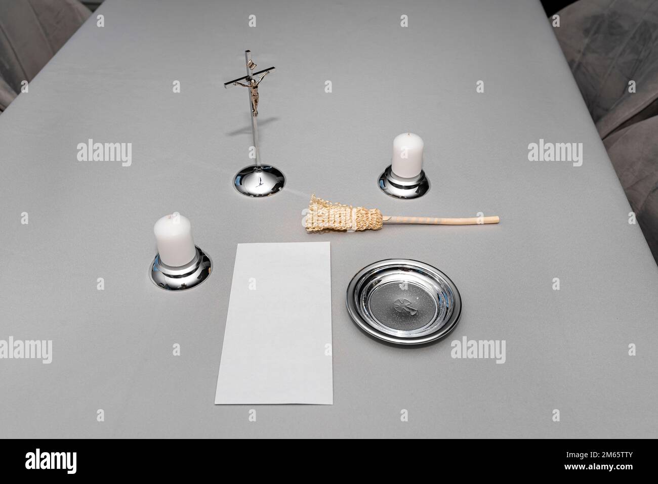 A steel caroling set lying on a gray tablecloth, traditional priest caroling in Poland, with an envelope with money. Stock Photo