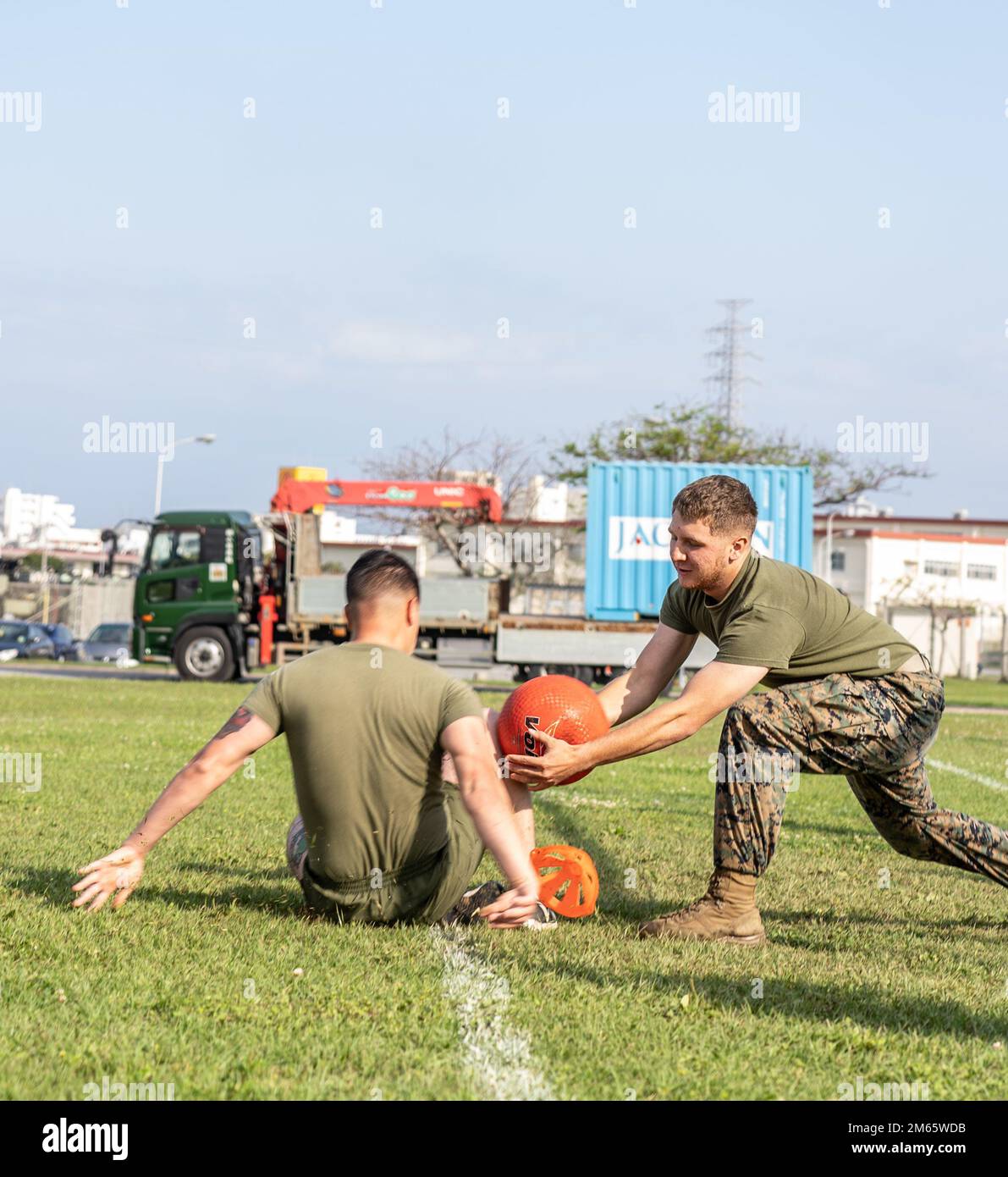 U.S. Marine Corps Pfc. Jesse Brambila, a motor transport operator with 3rd Transportation Battalion, Combat Logistics Regiment 3, 3rd Marine Logistics Group, tags a competitor with a ball during a field meet at Camp Foster, Okinawa, Japan, April 5, 2022. 3rd TB conducted a competitive field meet in order to boost morale amongst their Marines. 3rd MLG, based out of Okinawa, Japan, is a forward-deployed combat unit that serves as III MEF’s comprehensive logistics and combat service support backbone for operations throughout the Indo-Pacific area of responsibility. Stock Photo