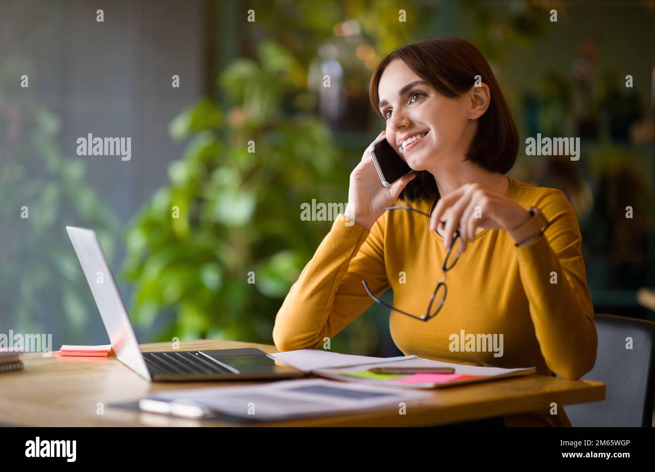 Attractive young businesswoman working at coffee shop Stock Photo
