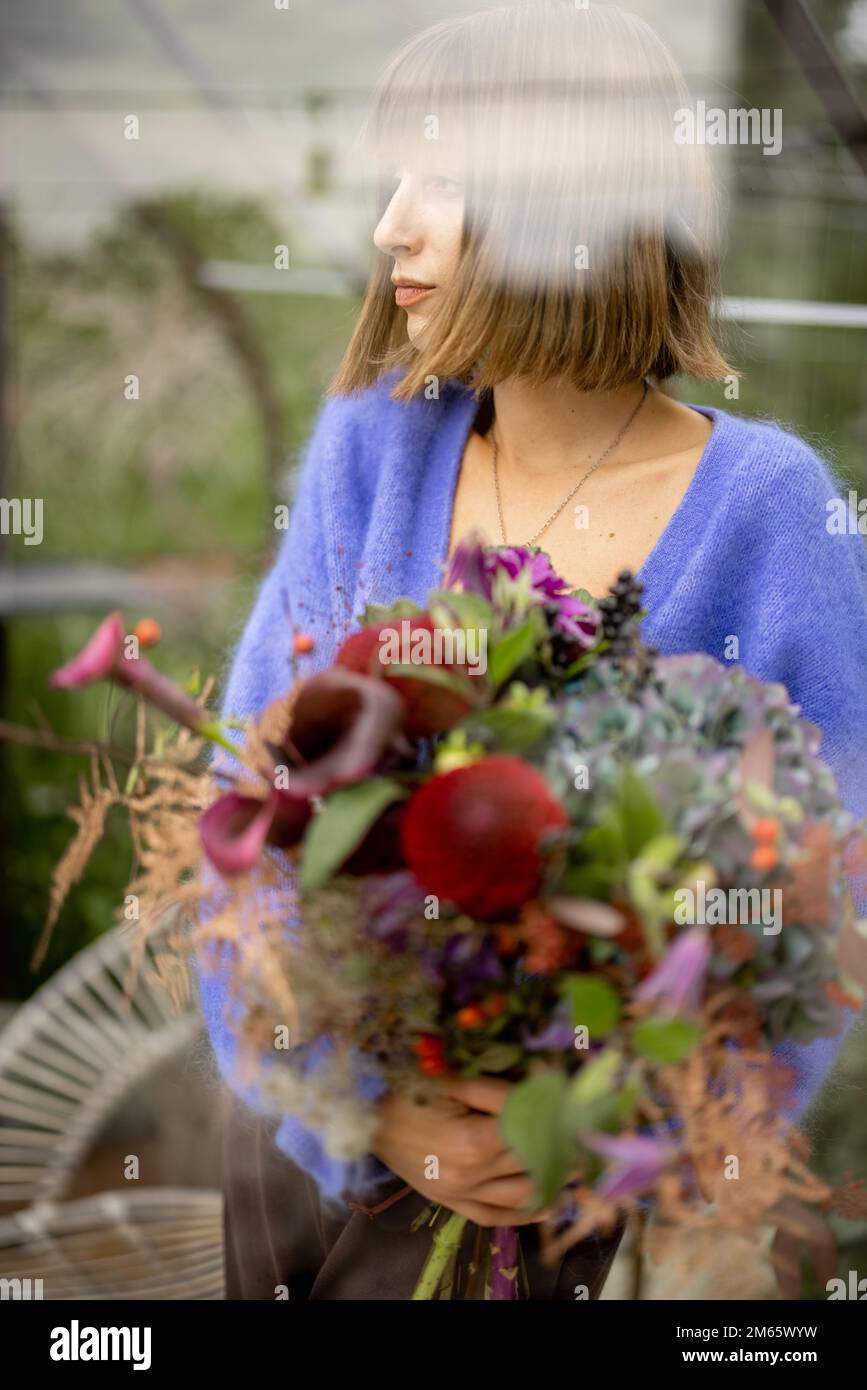 Woman with bouquet of flowers in garden Stock Photo