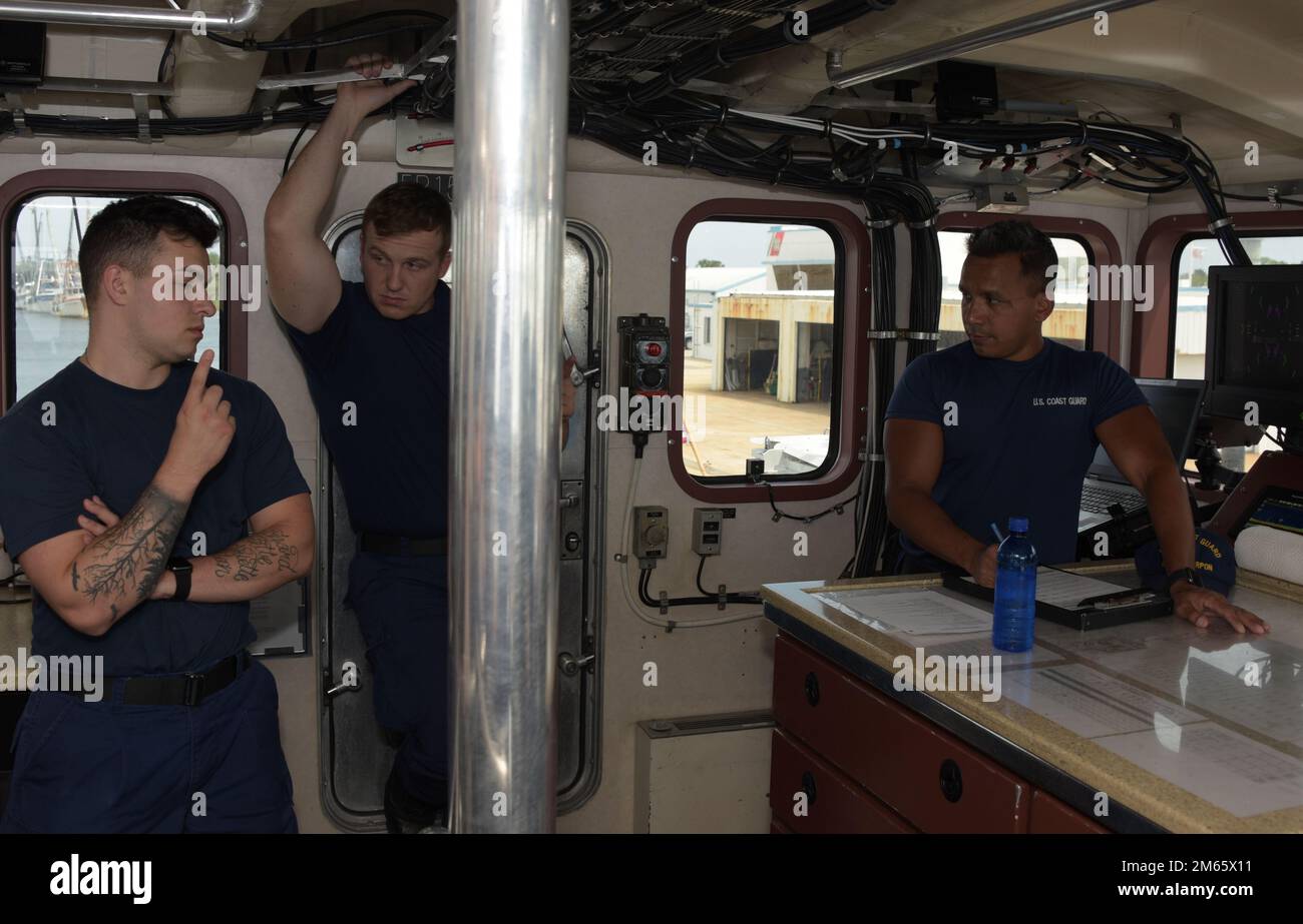 U.S. Coast Guard Petty Officer 1st Class Matthew McCorcle, right, a boatswains mate and operations petty officer aboard the coastal patrol boat USCGC Tarpon (WPB 87310), conducts a navigation briefing prior to getting underway from Coast Guard Sector Jacksonville, Florida, April 5, 2022. The Tarpon is an 87-foot marine-protector class patrol boat capable of performing search and rescue, law enforcement, fishery patrols, drug interdiction, illegal immigrant interdiction and homeland security duties up to 200 nautical miles offshore. Stock Photo