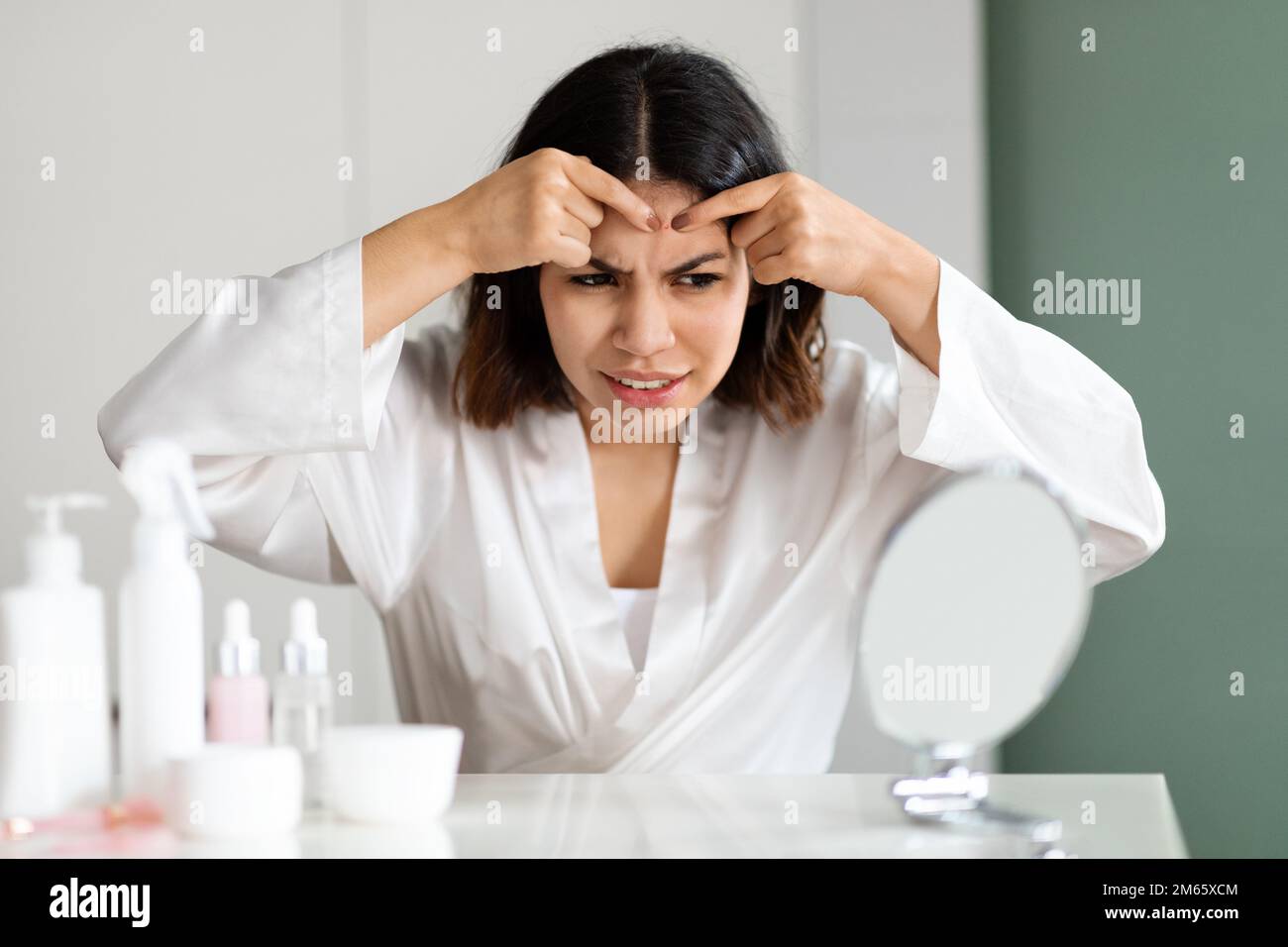 Irritated young woman suffering from acne, pop pimples Stock Photo Alamy