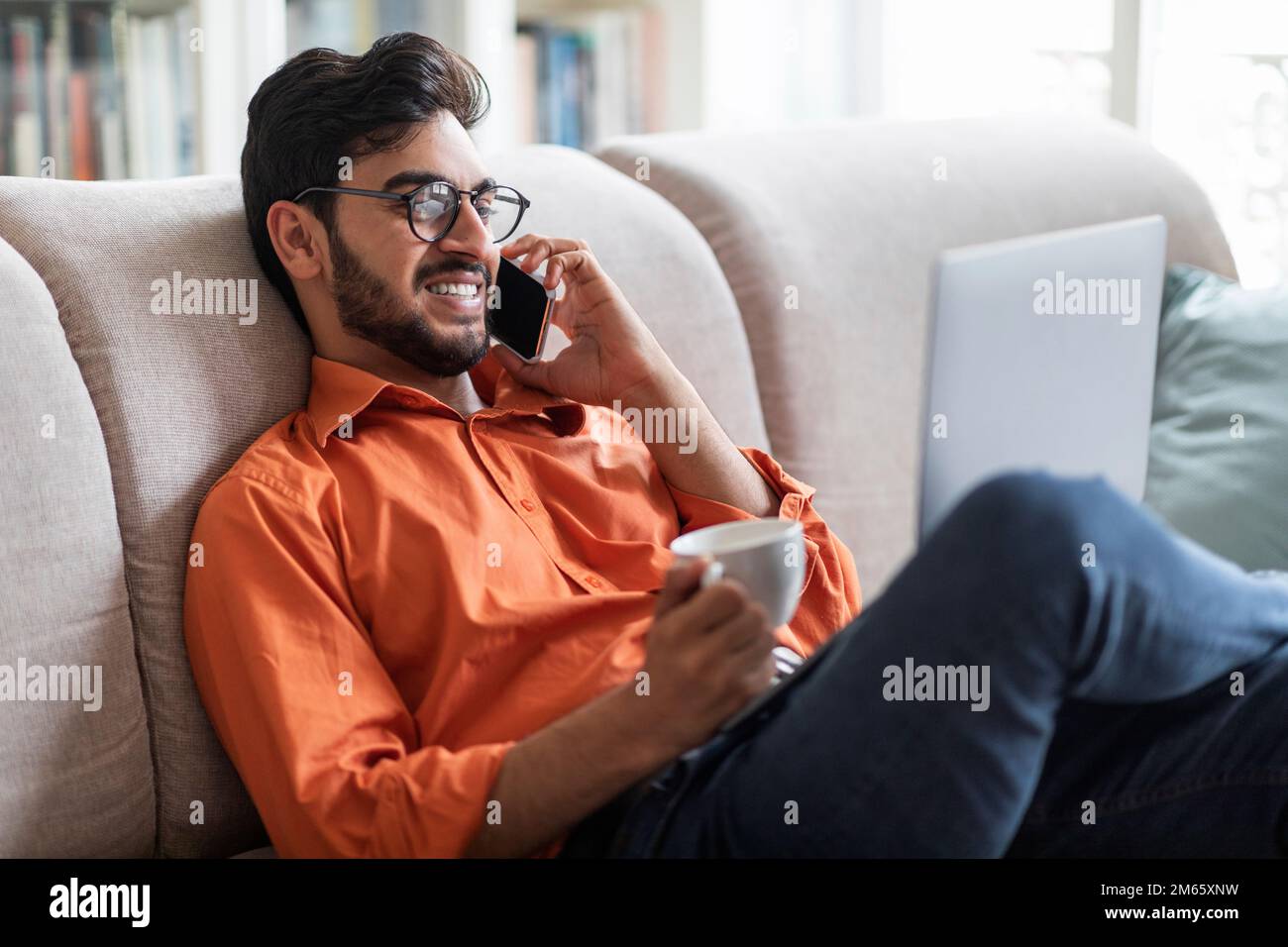 Handsome arabic man resting at home, using laptop Stock Photo