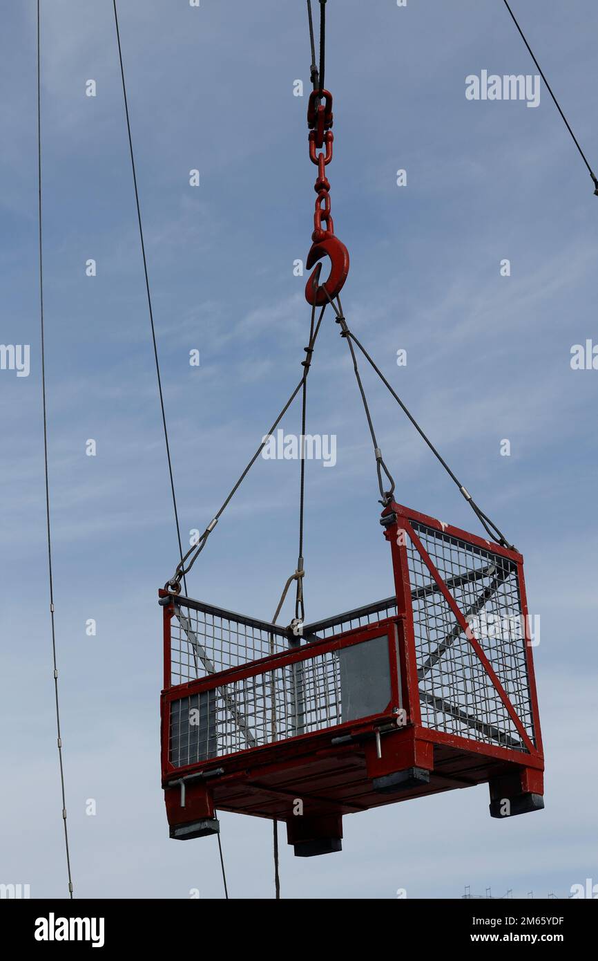 Red lattice box hangs in the air on a hook Stock Photo