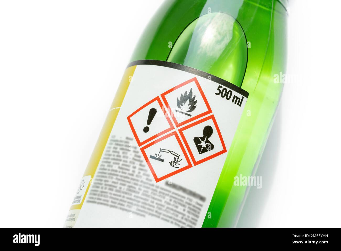 A green bottle of highly corrosive flammable chlorinated rubber nitro solvent with printed on warning symbols label, sticker. Dangerous chemical subst Stock Photo
