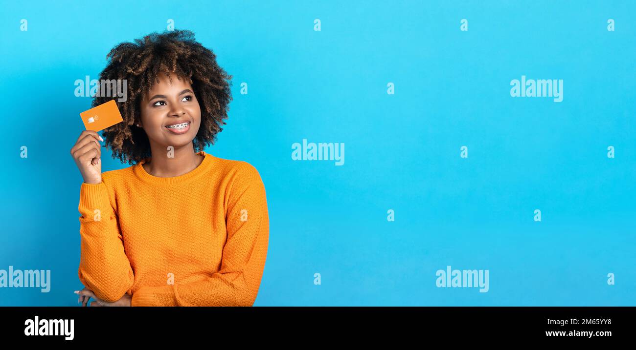 Positive black lady with credit card looking at copy space Stock Photo ...