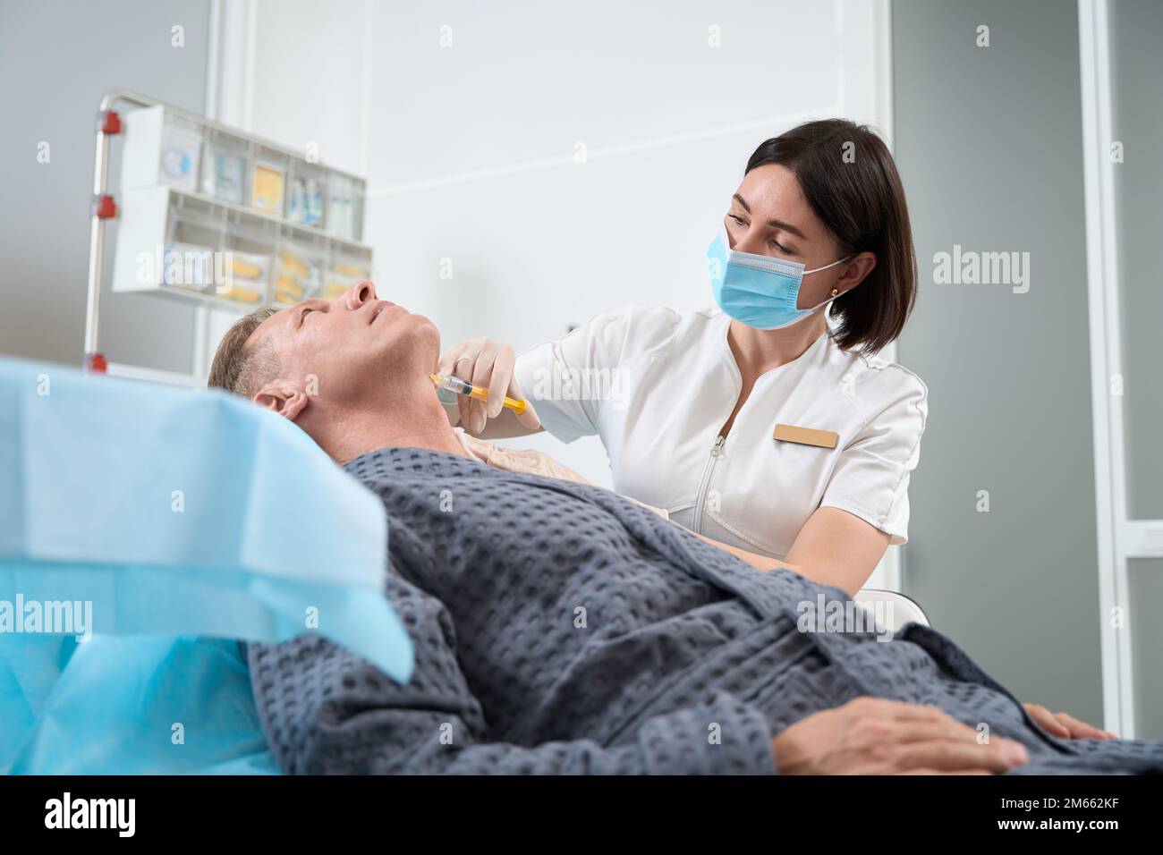 Modern clinic patient having a skin rejuventaion injection into neck ...