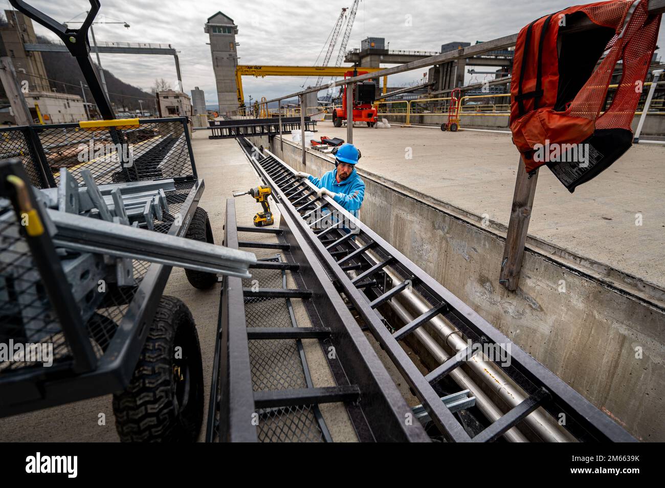Jason Kreminski, an electrician, runs cable trays in a control channel