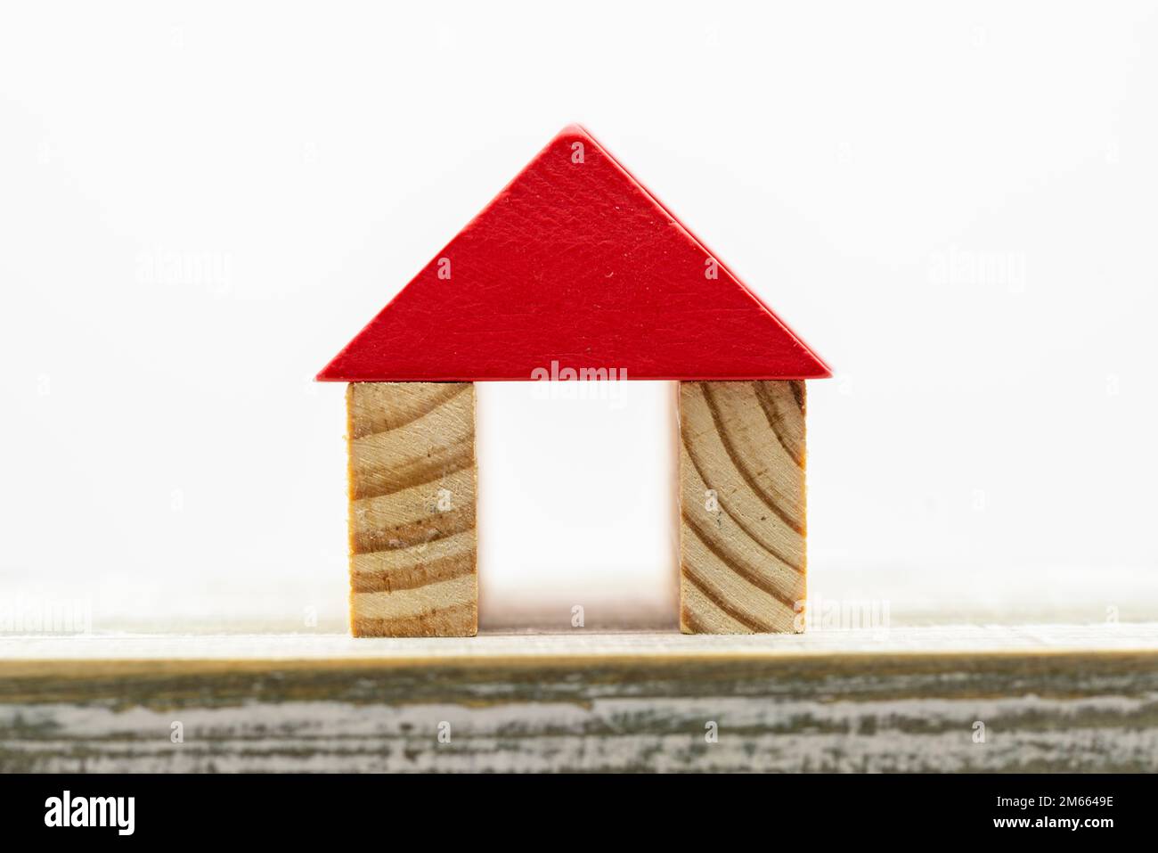 Casita en miniatura formada con tacos de madera con fondo blanco Stock Photo