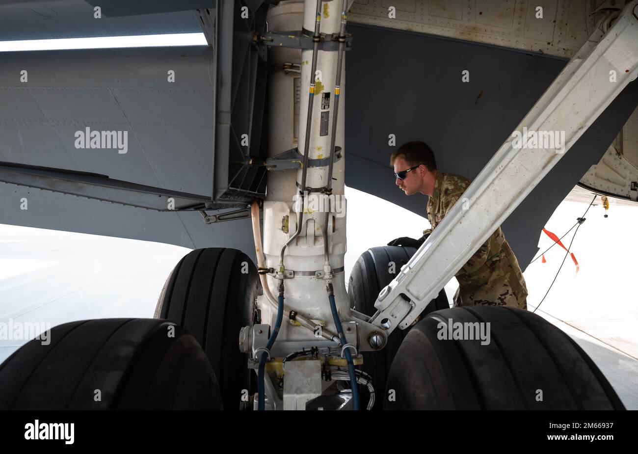 U.S. Air Force Maj. Thomas Evans, a KC-135 Stratotanker aircraft pilot assigned to 340th Expeditionary Air Refueling Squadron, inspects the outside of a U.S. Air Force KC-135 Stratotanker assigned to the 340th EARS before flight operations at Al Udeid Air Base, Qatar, April 6, 2022. The 340th EARS deployed with the Ninth Air Force (Air Forces Central), is responsible for delivering fuel to U.S. and partner nation forces, enabling airpower, deterrence, and stability. Stock Photo