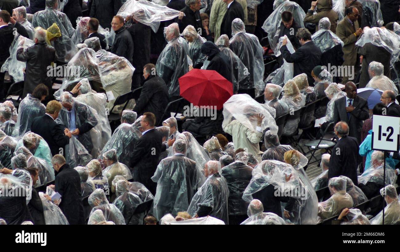 Papst Benedikt XVI im Berliner Olympia-Stadion Josef Ratzinger Die Besucher des Papstes lassen sich vom Regen nicht schrecken und schützen sich mit Plastikumhängen. Nur einer belebt das Bild mit einem roten Schirm. Stock Photo