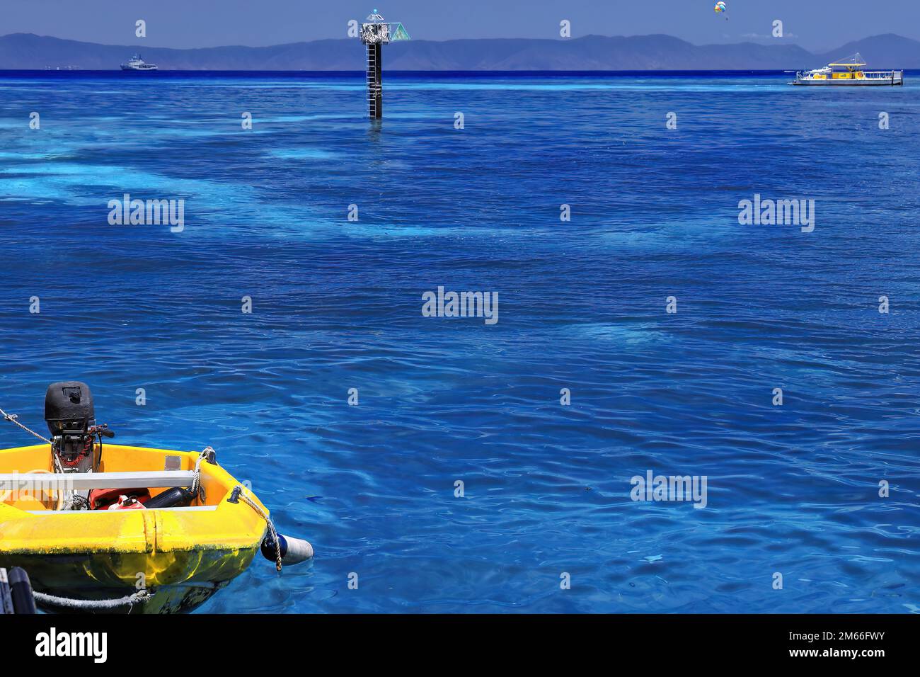 377 Yellow dinghy-starboard beacon-tourist pontoon-hydrographic survey vessel, all seen from the Green Island jetty. Queensland-Australia. Stock Photo