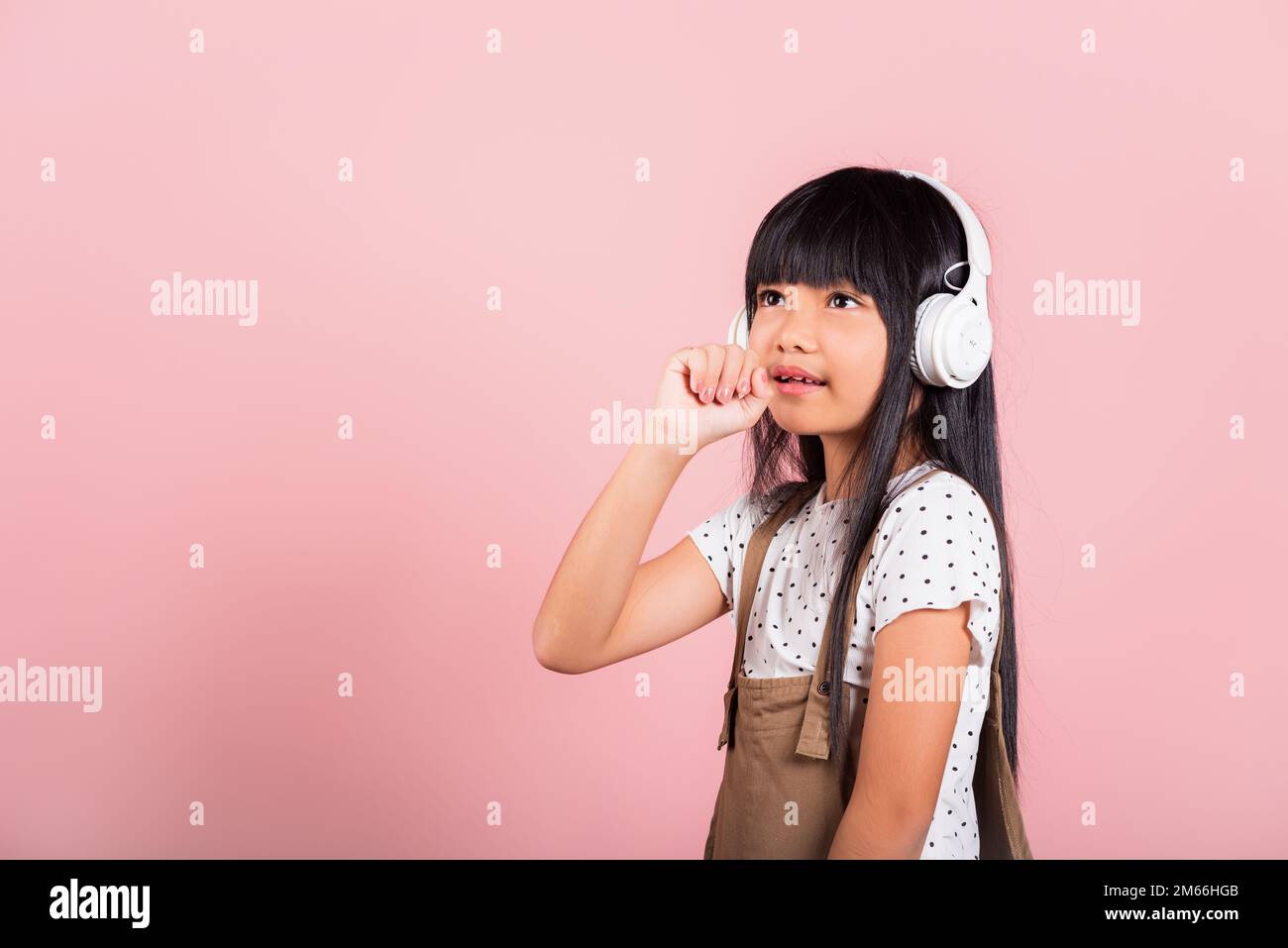 Asian little kid 10 years old smile listening music wear wireless