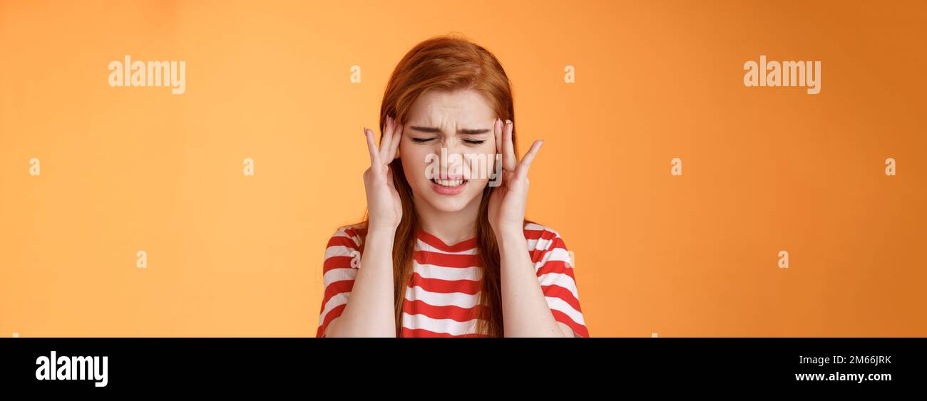 Dizzy uneasy cute redhead female student suffering huge headache, cringe, frowning clench teeth