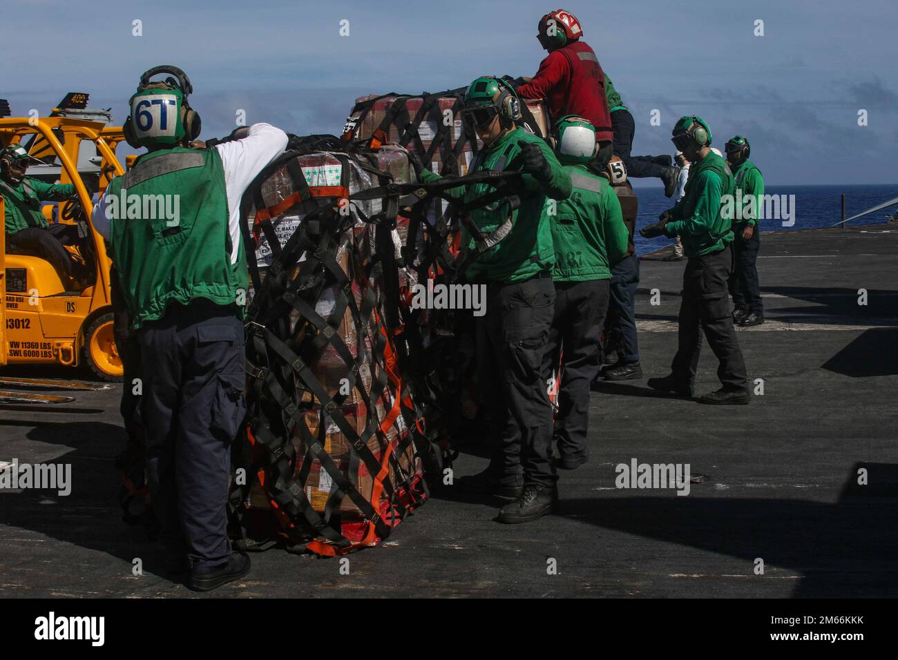PHILIPPINE SEA (April 7, 2022) Sailors remove cargo nets on the flight deck of the Nimitzclass