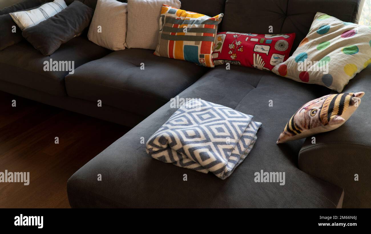 Cozy couch blanket with pillows in a modern living room setting. Everyday life concept Stock