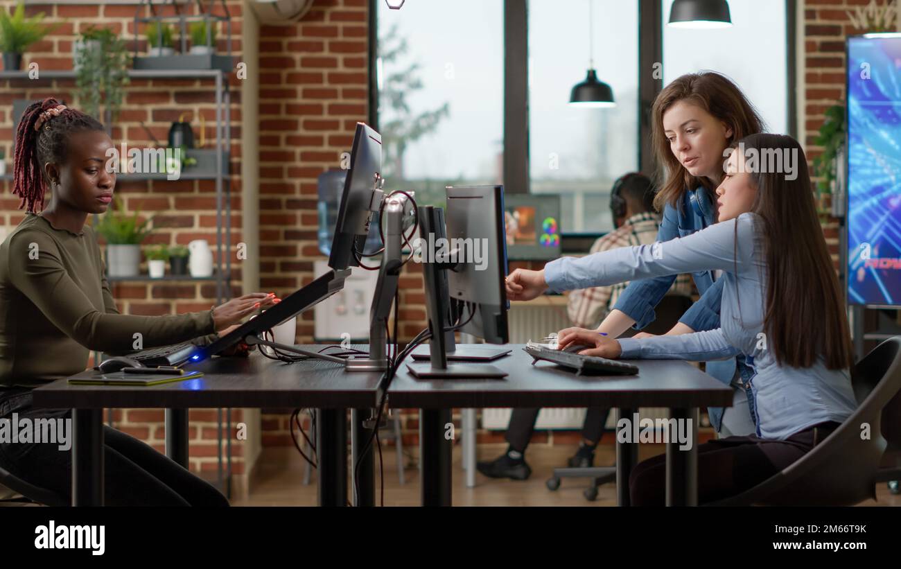 Professional office workers analyzing blueprint project on multi monitors, using engineering software on pc. Creative designers developing art on computer, discussing about 3D technology. Stock Photo